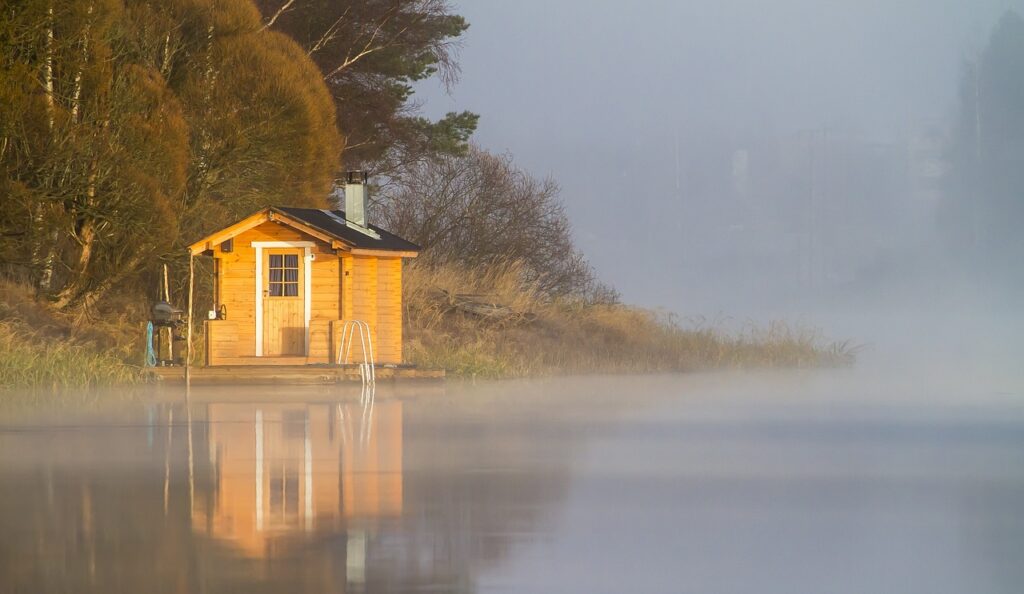 Kuvassa näkyy suomalainen saunalautta järven rannalla. 